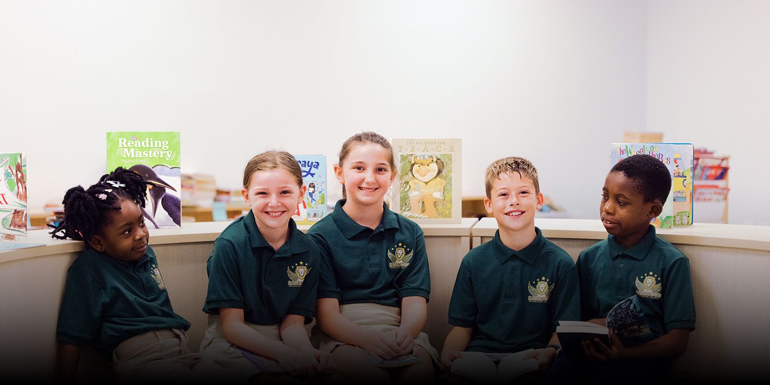 Smiling children in the school library surrounded by books