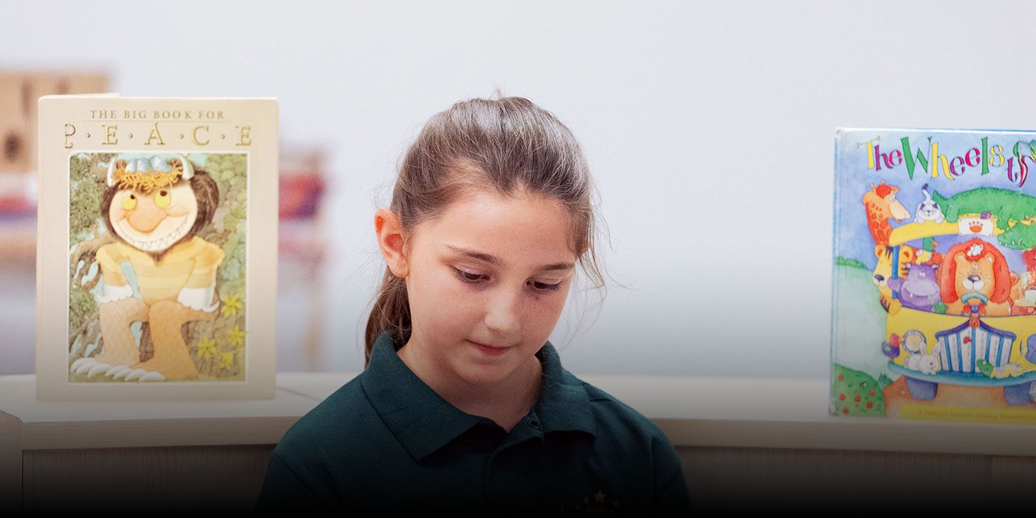 Student reading a book in the school library